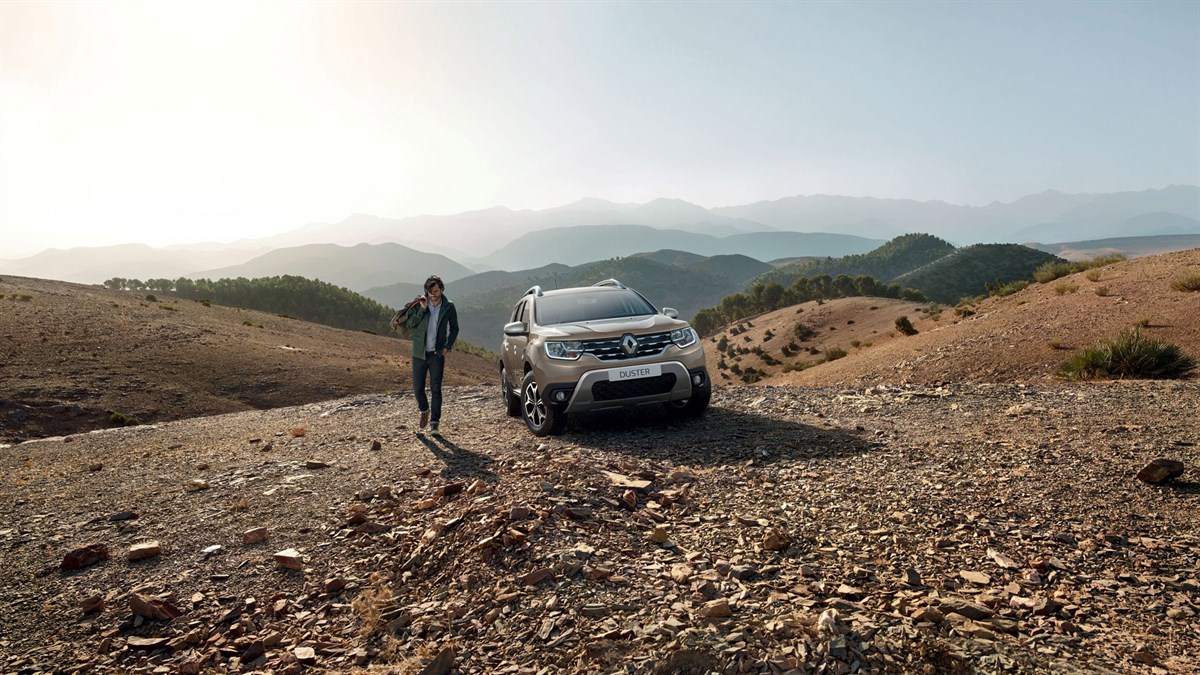 A man walking out from his Renault Duster parked on a desert
